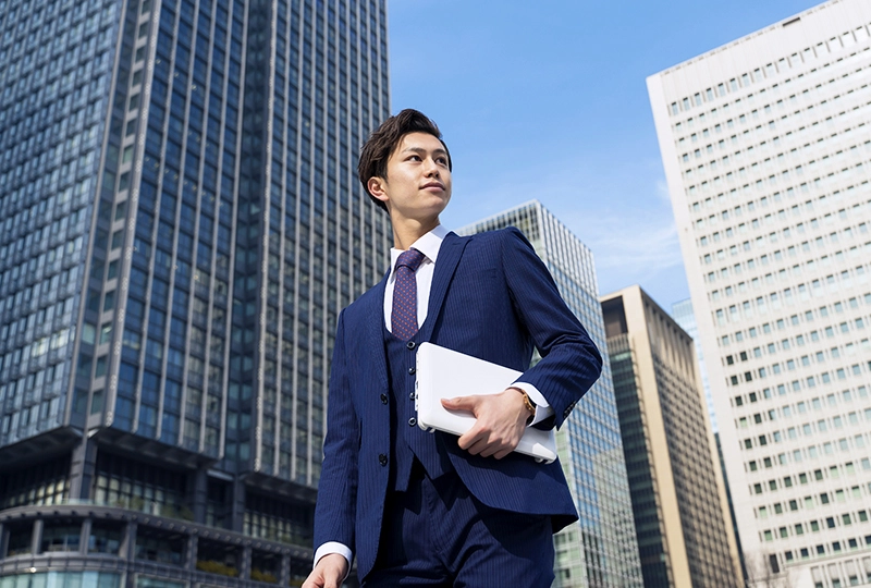 スーツを着てビジネス街を歩く新社会人の男性の写真