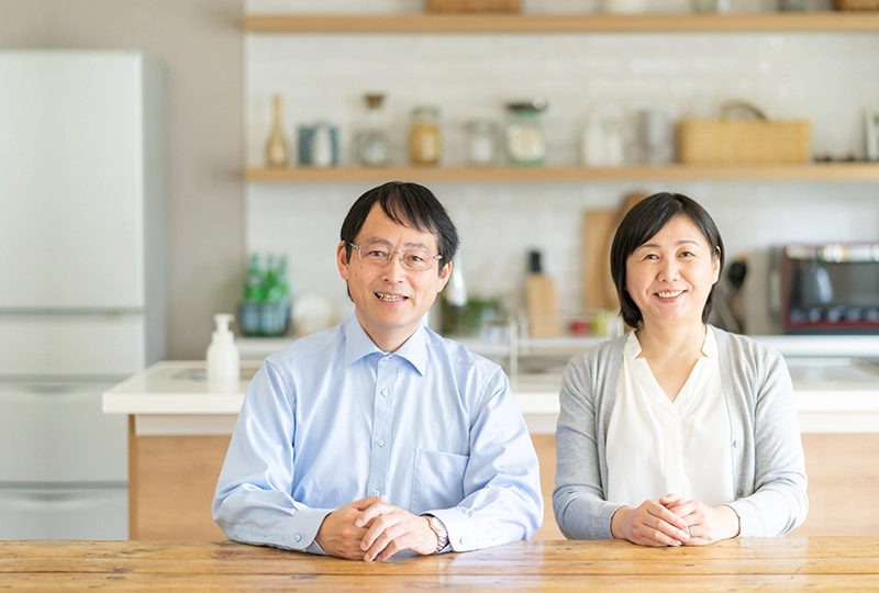 家の中で二人で微笑む60代夫婦の写真