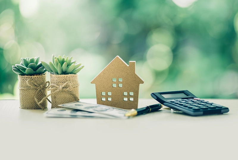 家の模型と電卓やお金が置かれ住宅購入を検討している写真